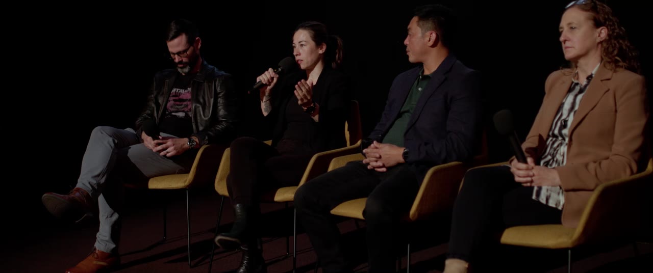 Kelly answering questions on stage after an Invisible Injuries screening